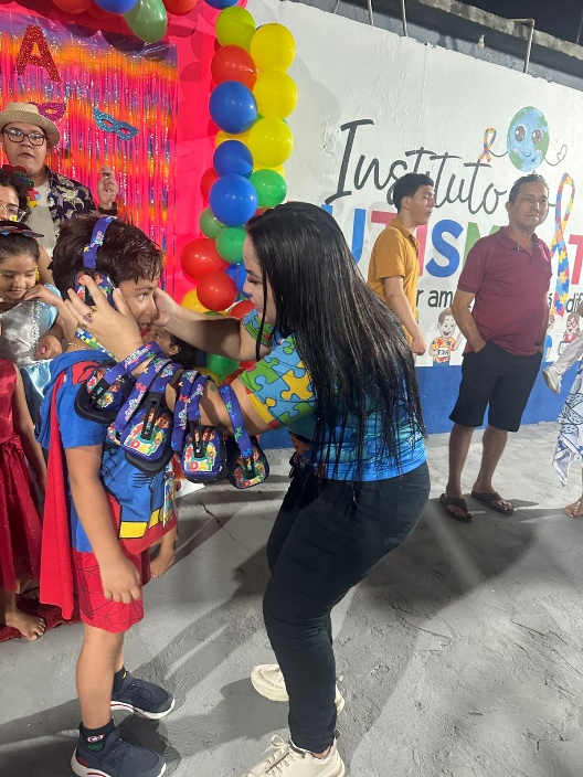 Entrega de abafadores de ruído a criança atendida pelo IDAT